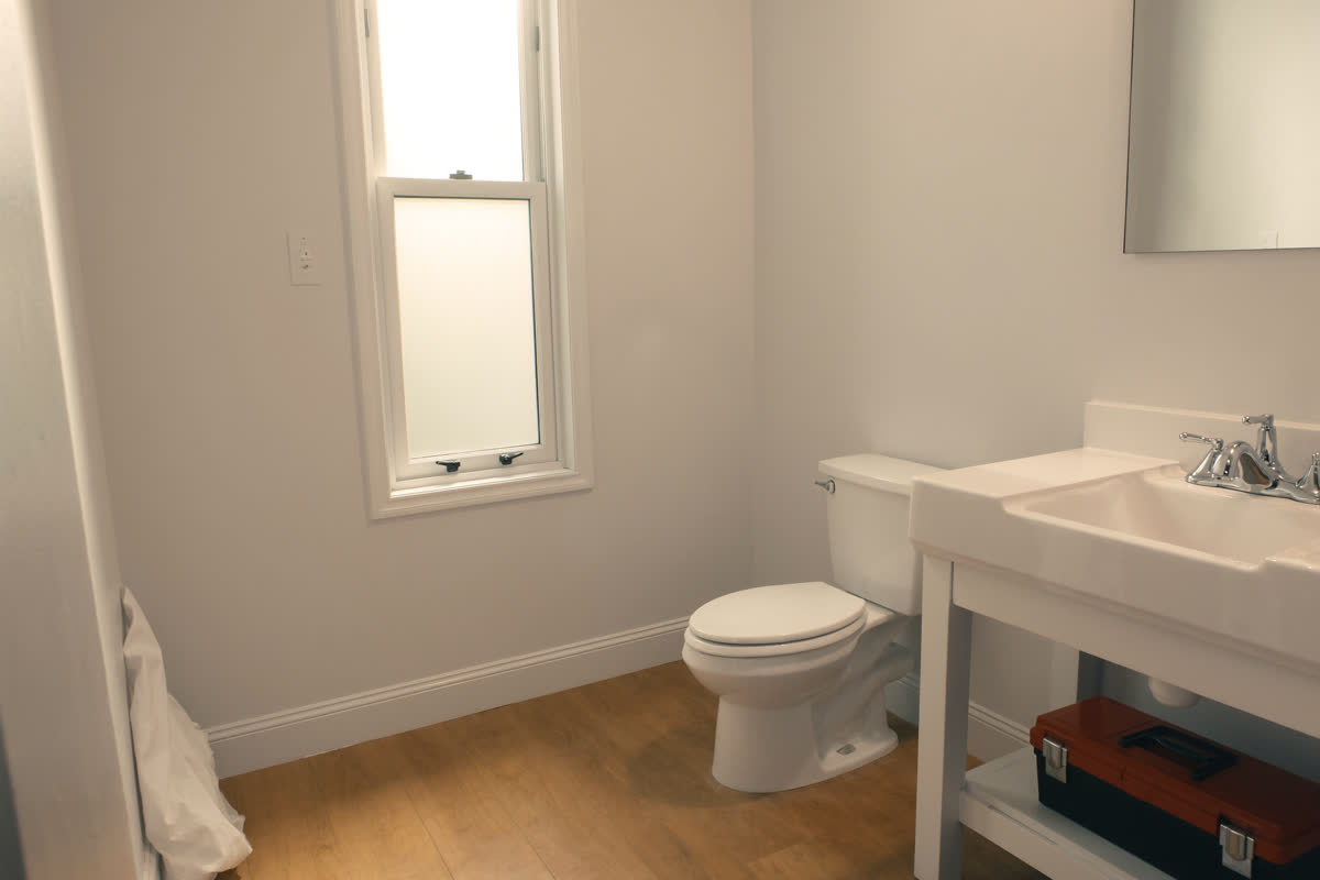 Spotless renovated bathroom with a packed toolbox after the job