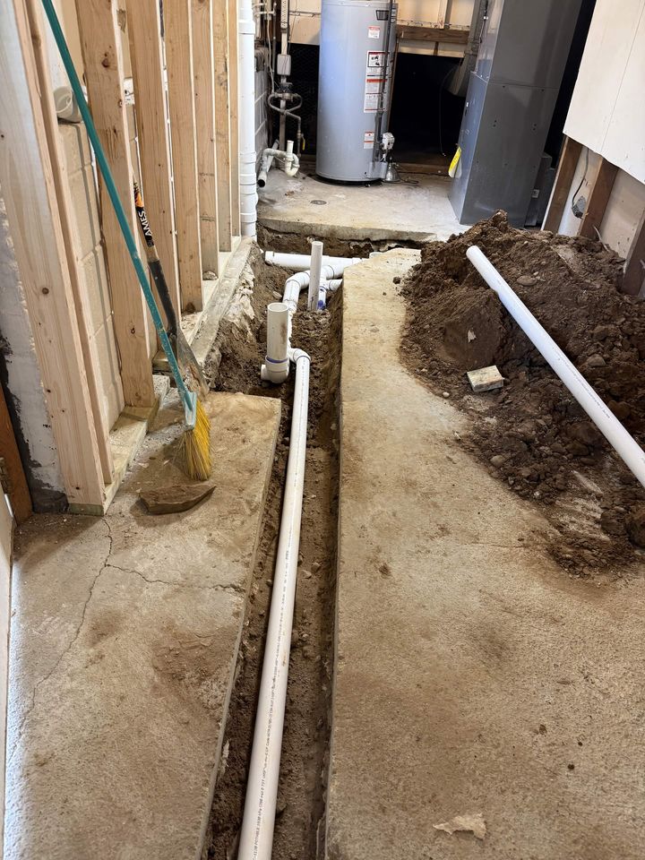 Basement slab trenched for new waste lines alongside the water heater
