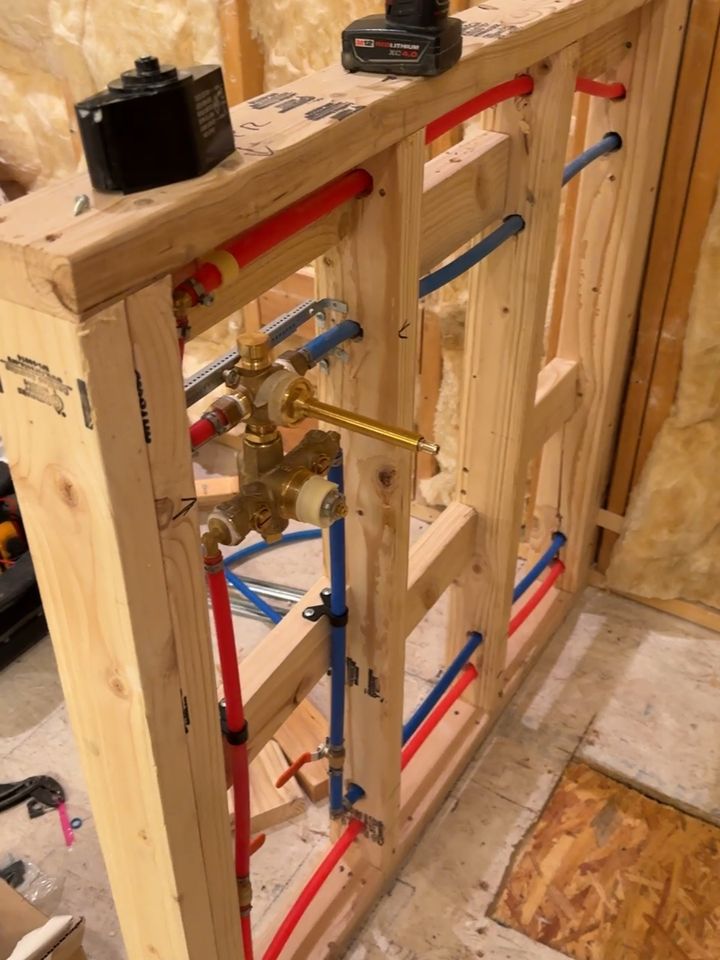 PEX manifold rough-in with hot and cold home runs framed into a new stud wall