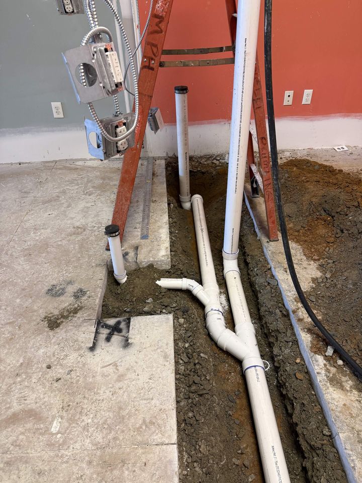PVC drain line rough-in set in an excavated trench
