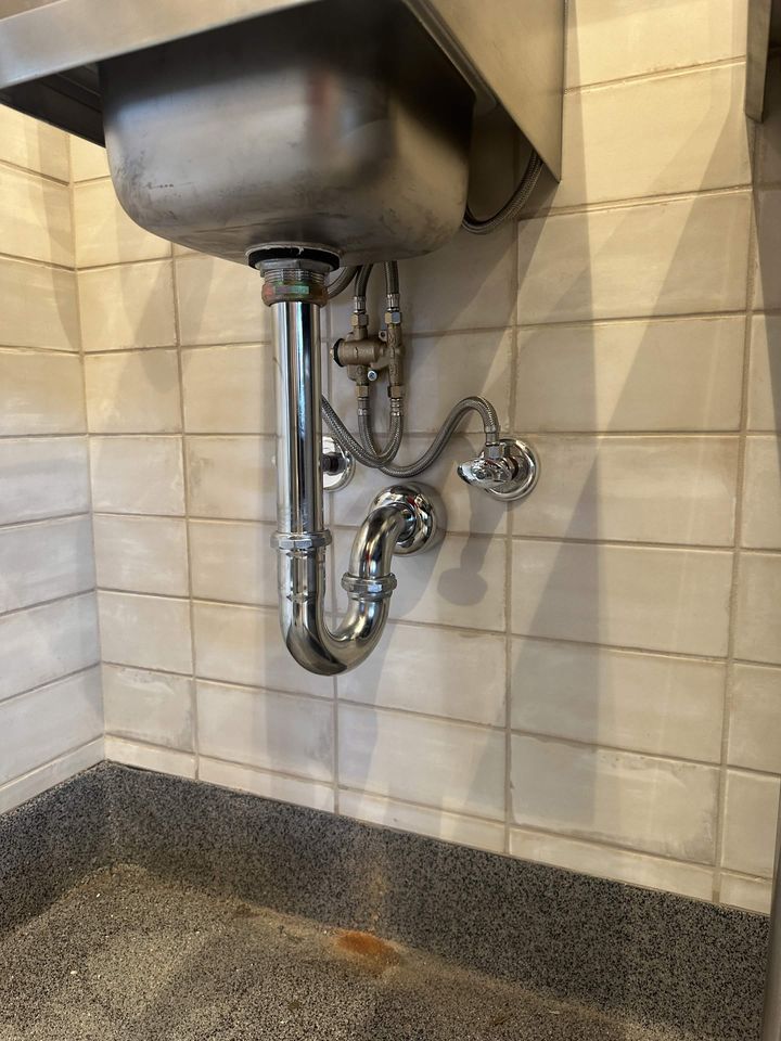 New P-trap and drain assembly under a stainless steel sink