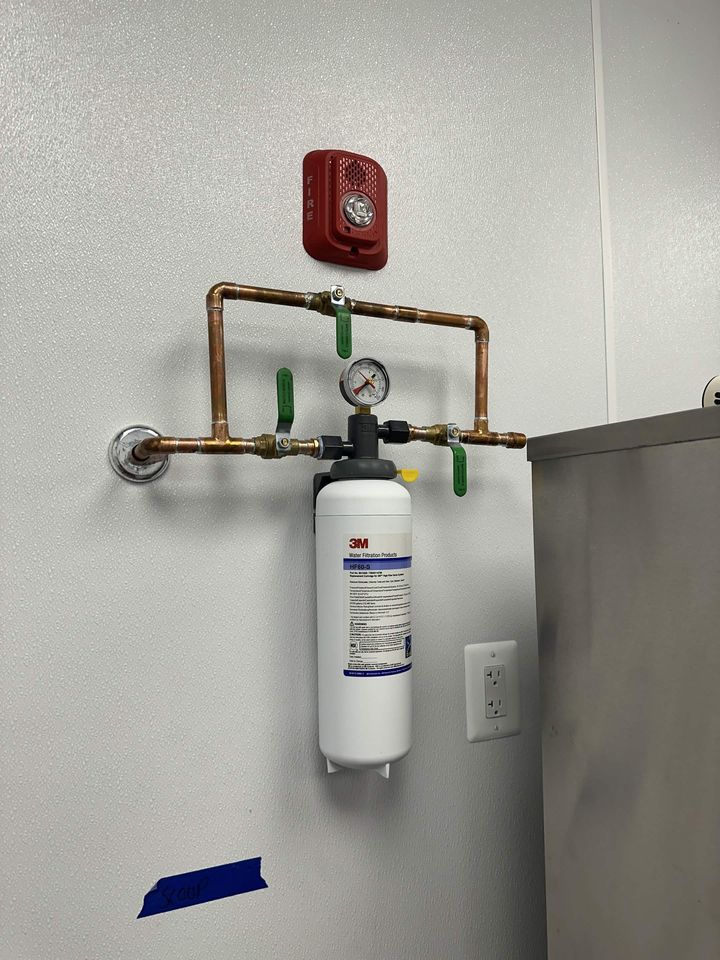 Water filtration system plumbed in copper with shutoff valves and a pressure gauge